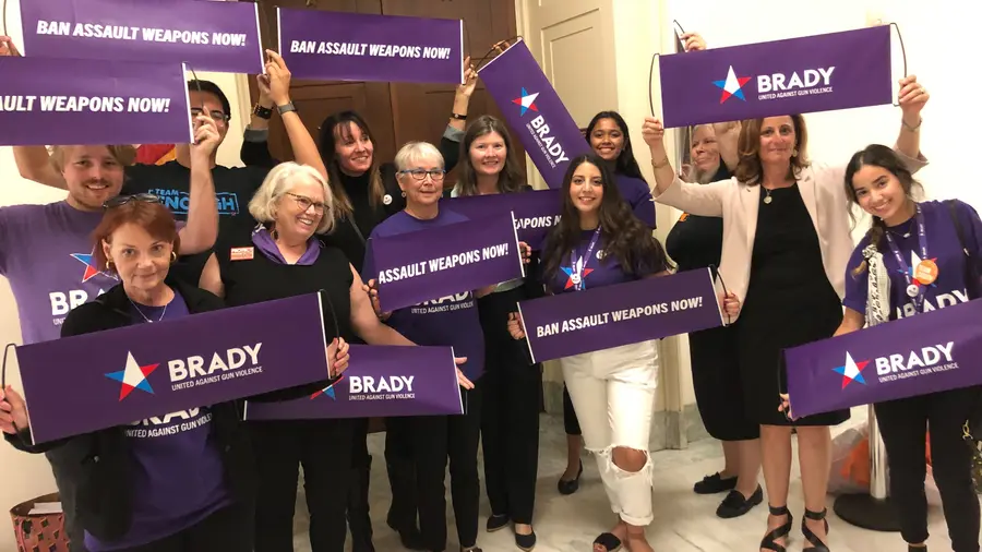A group of brady members pose with Brady and Ban Assault Weapons sign in 2019