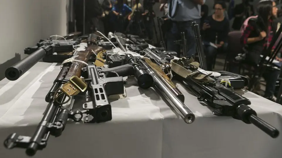 Multiple guns laying on a display table with bump stock attachments.