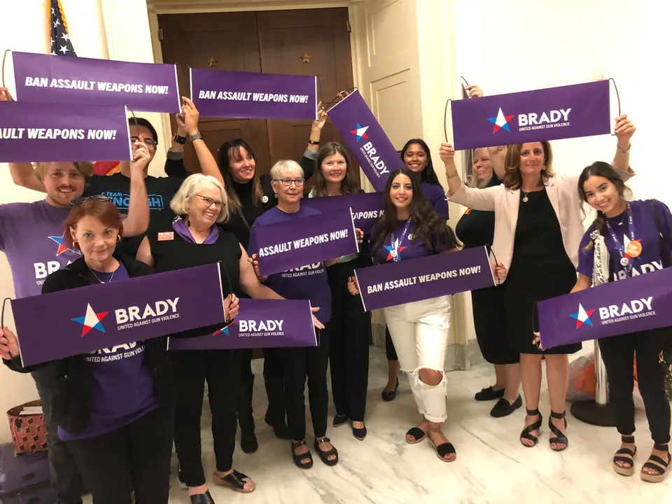 A group of brady members pose with Brady and Ban Assault Weapons sign in 2019