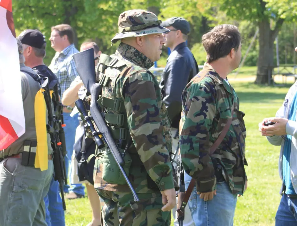 Man at Hunt Park wearing a camo outfit and carrying a long gun during a 2a protest
