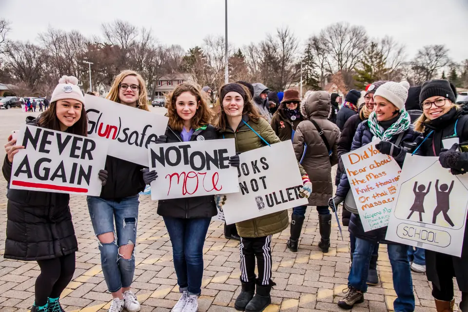 Teens at the march for our lives 2022 rally pose with signs against school violence